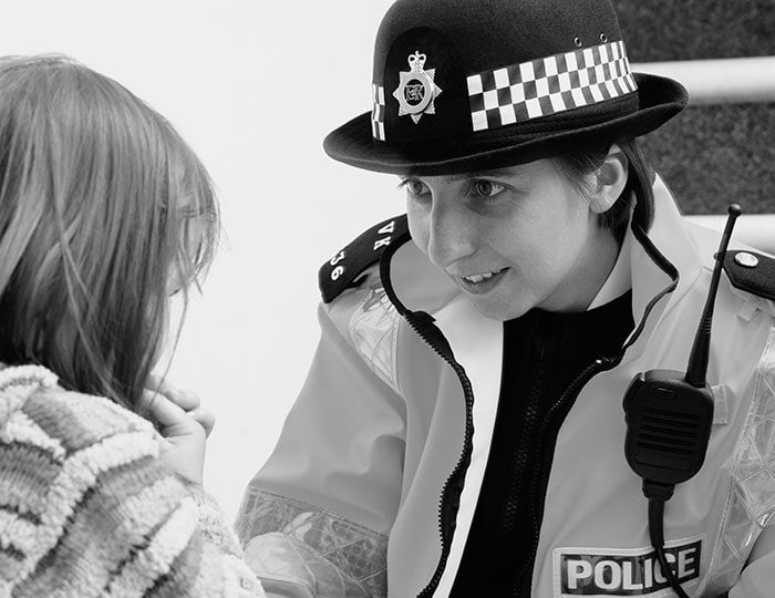 Policewoman talking to girl in community