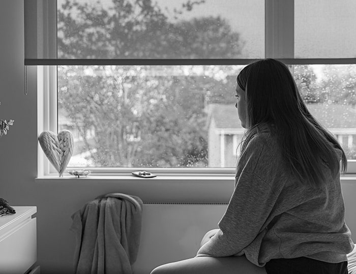 Upset teenager looking out of window