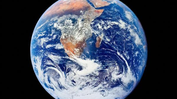 A view of Earth from space showing the African continent, surrounded by vast blue oceans and swirling white clouds against the black backdrop of space.