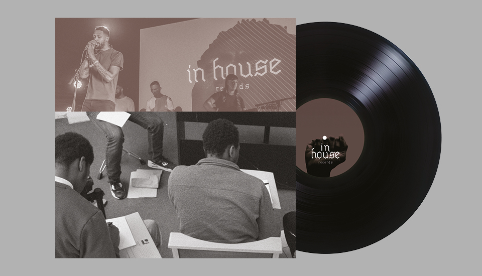 A vinyl record with a cover showing a sepia-toned photo of a man singing into a microphone on stage, with "in house records" in the background. Below, three people are sitting and writing in notebooks.