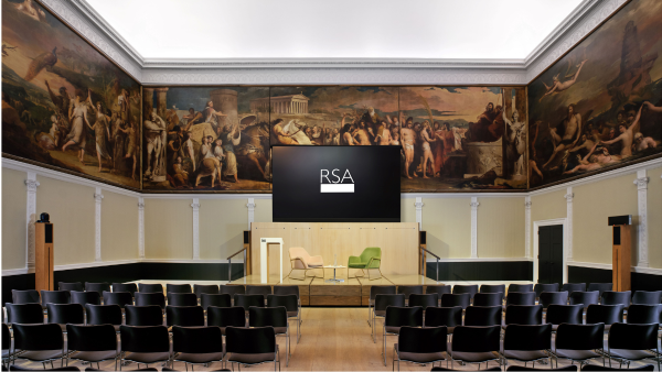 Lecture hall with rows of black chairs facing a stage with three armchairs and a large screen displaying "RSA." The walls are adorned with elaborate classical paintings depicting historical scenes.