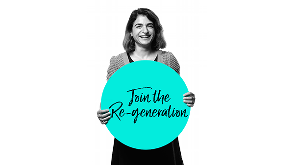 A smiling person holds a turquoise circular sign with the text "Join the Re-generation" written in black cursive. The image is in black and white, with the exception of the sign.