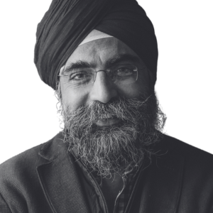 A grayscale portrait of a person wearing glasses and a turban captures their slight smile with a full beard. The plain white background highlights their features, reminiscent of the dignified leaders you'll meet when you join us to celebrate the opening of the UK Pavilion at Expo 2025 Osaka.