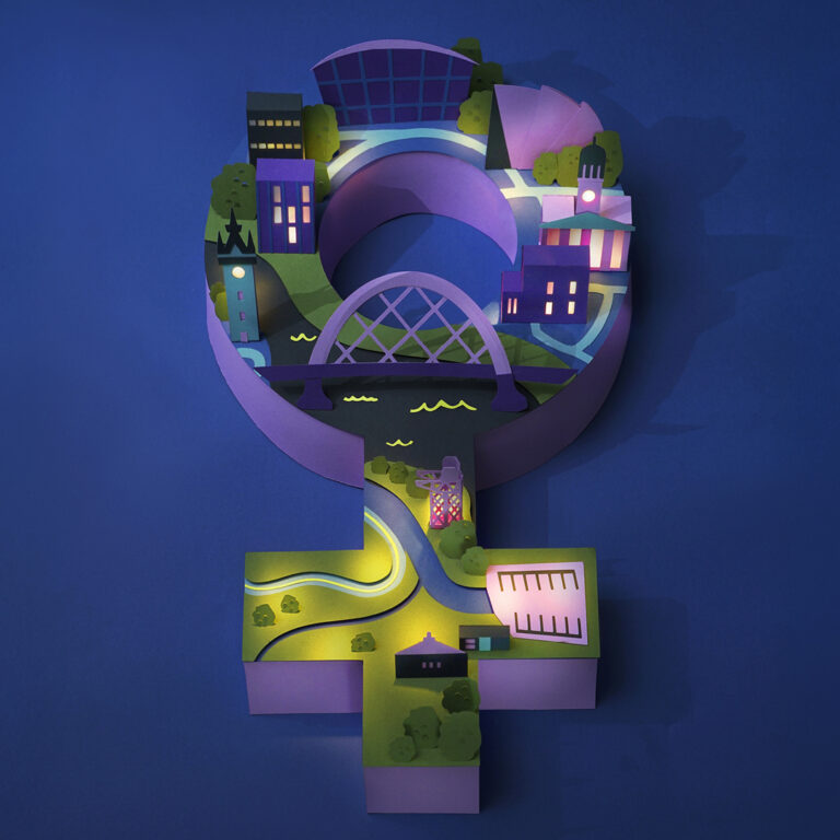 A 3D paper-cut illustration of the female gender symbol, featuring miniature city buildings, a bridge, trees, and winding roads on a blue background, symbolizing women’s roles in urban environments.