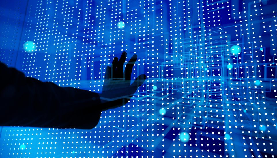 A hand reaches toward a glowing digital screen filled with blue and white dots and lines, suggesting interaction with futuristic technology or data visualization.