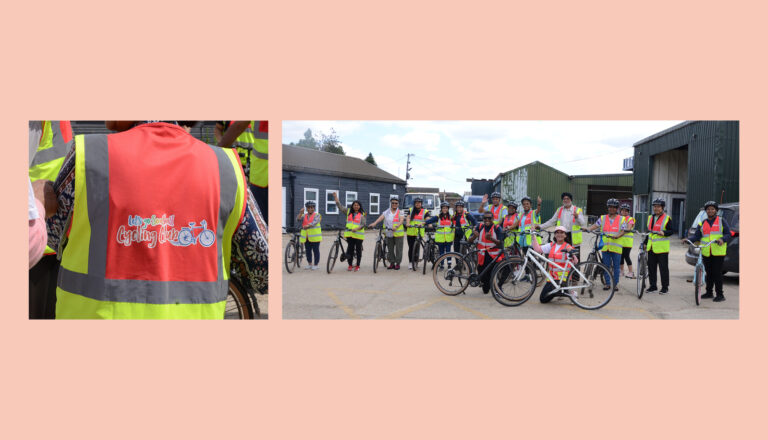 A group of people wearing high-visibility vests and helmets stand with their bicycles outside industrial buildings, fostering social connections in the Ealing community; close-up inset shows the "Unfinished Cycles Project" logo on a vest.