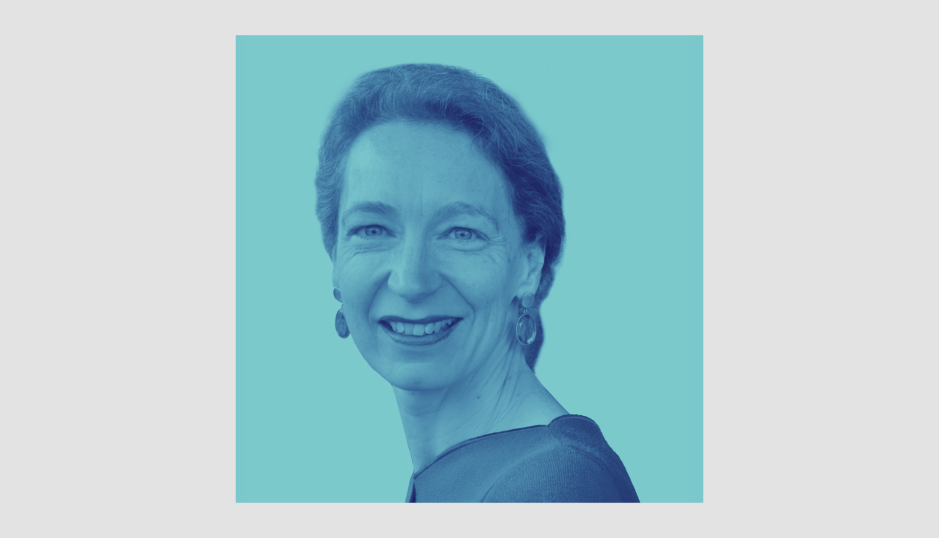 A woman with short hair smiling, wearing earrings and a top, shown in a blue monochrome filter on a solid light blue background.